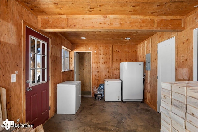 clothes washing area featuring electric panel and wooden walls