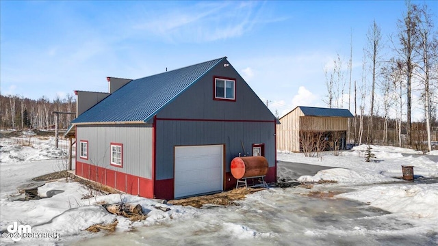 snow covered garage featuring a detached garage