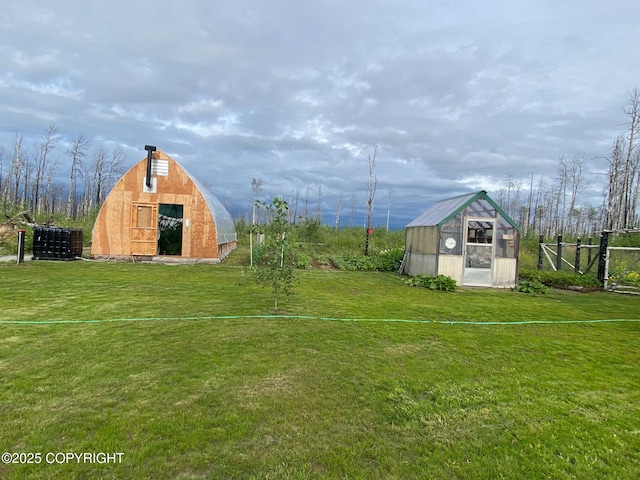 view of yard featuring an outbuilding, fence, and a barn