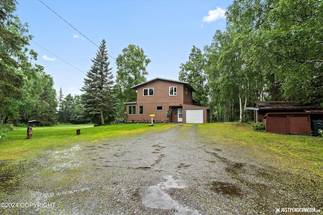 view of front of property featuring driveway, a front yard, and a garage