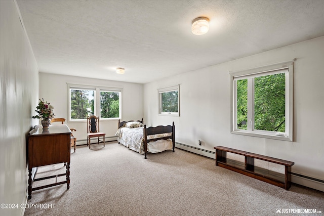carpeted bedroom featuring a textured ceiling and baseboard heating