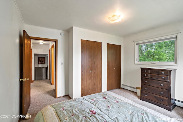 bedroom featuring multiple closets, carpet, and a baseboard radiator