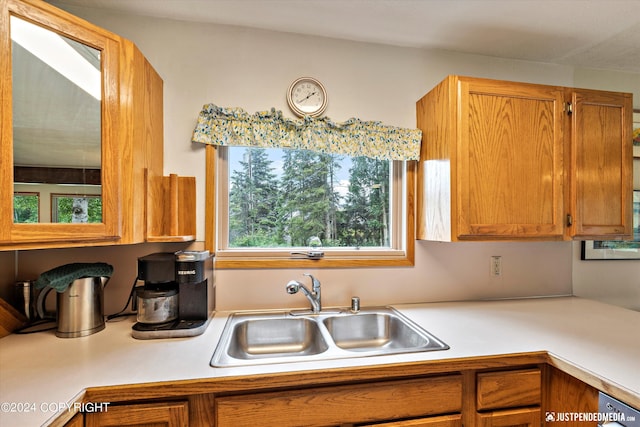 kitchen featuring brown cabinetry, a sink, and light countertops