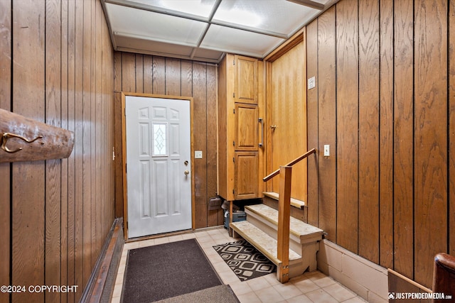 entryway with wooden walls and stairway