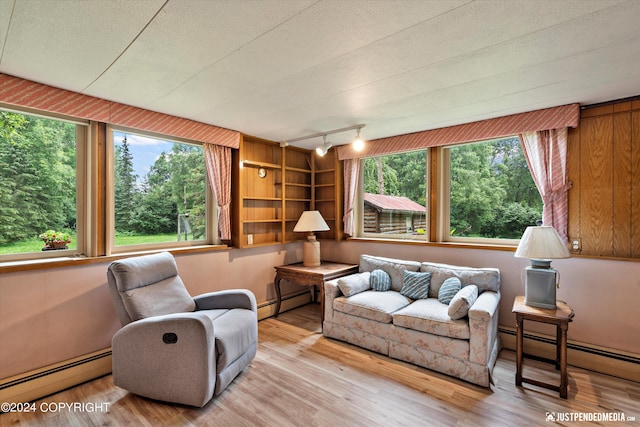 living room featuring a baseboard heating unit and wood finished floors