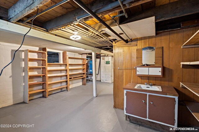 unfinished basement with a sink and wood walls