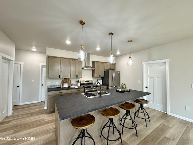 698 Wortham Ave, Kenai, AK 99611 - kitchen featuring appliances with stainless steel finishes, dark countertops, wall chimney range hood, a kitchen breakfast bar, and light wood-type flooring
