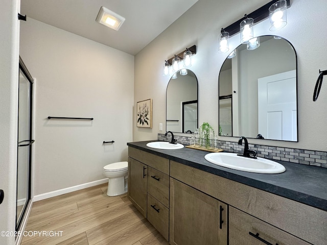 698 Wortham Ave, Kenai, AK 99611 - full bathroom featuring double vanity, wood finished floors, tasteful backsplash, and a stall shower