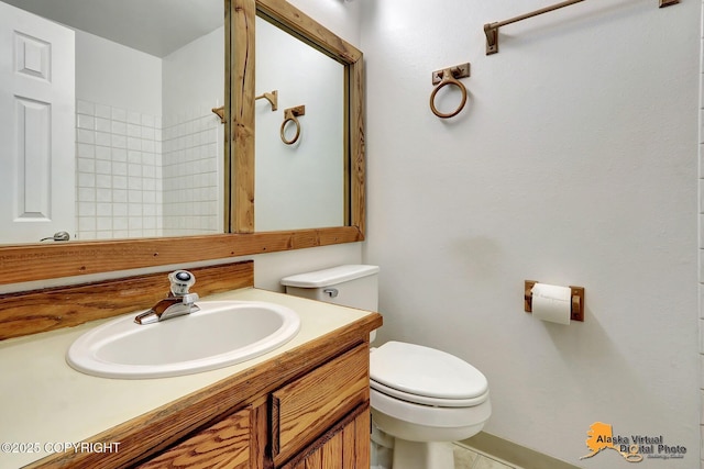 bathroom with toilet, vanity, and tile patterned flooring