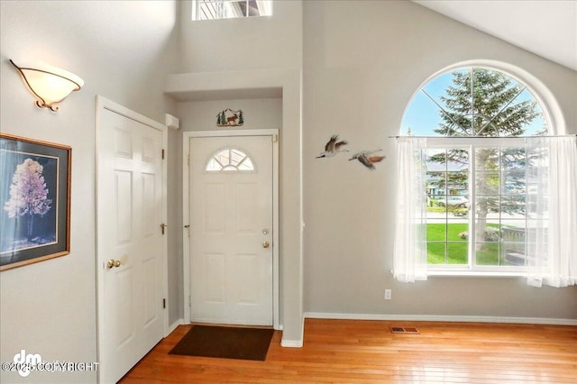 19016 Mountain Point Cir, Eagle River, AK 99577 - entrance foyer featuring plenty of natural light, hardwood / wood-style floors, a high ceiling, and baseboards