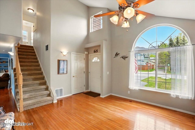 19016 Mountain Point Cir, Eagle River, AK 99577 - foyer entrance featuring plenty of natural light, wood-type flooring, stairway, baseboards, and a high ceiling