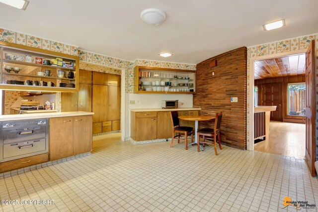 204 E 15th Ave, Anchorage, AK 99501 - kitchen with open shelves, wallpapered walls, light countertops, and brown cabinets
