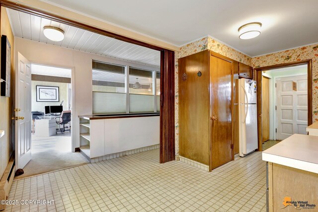 204 E 15th Ave, Anchorage, AK 99501 - kitchen featuring freestanding refrigerator, a desk, wallpapered walls, brown cabinets, and light countertops