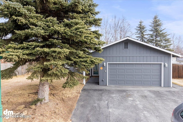 4801 Carousel Cir, Anchorage, AK 99502 - view of front of home with driveway, fence, and a garage