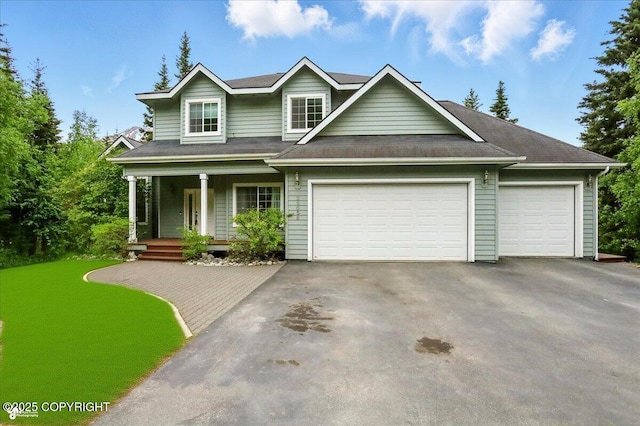 25656 Bendilent Cir, Eagle River, AK 99577 - view of front of property with driveway, covered porch, and a garage