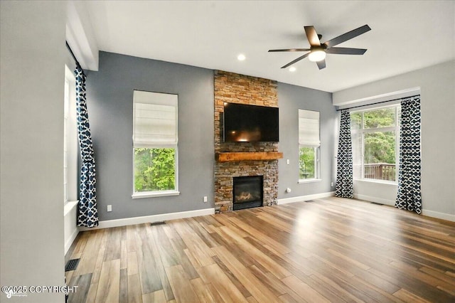 25656 Bendilent Cir, Eagle River, AK 99577 - unfurnished living room with a ceiling fan, wood finished floors, baseboards, a stone fireplace, and recessed lighting
