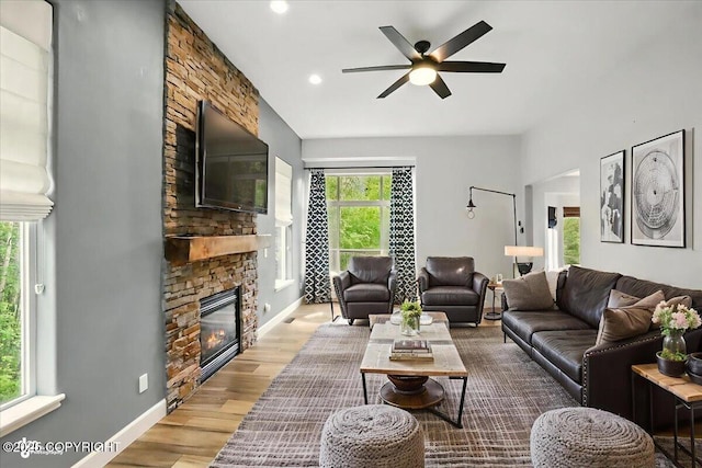 25656 Bendilent Cir, Eagle River, AK 99577 - living room featuring a stone fireplace, a ceiling fan, baseboards, wood finished floors, and recessed lighting