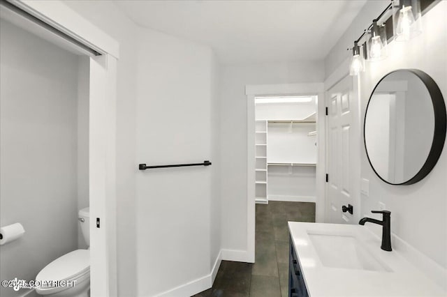 25656 Bendilent Cir, Eagle River, AK 99577 - bathroom featuring toilet, vanity, baseboards, and a spacious closet