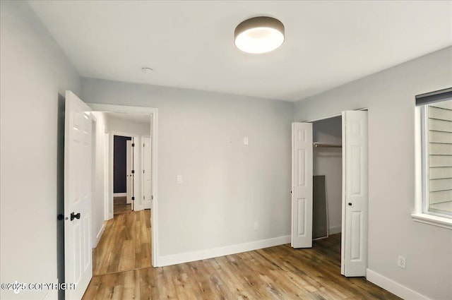 25656 Bendilent Cir, Eagle River, AK 99577 - unfurnished bedroom with wood finished floors, baseboards, and a closet