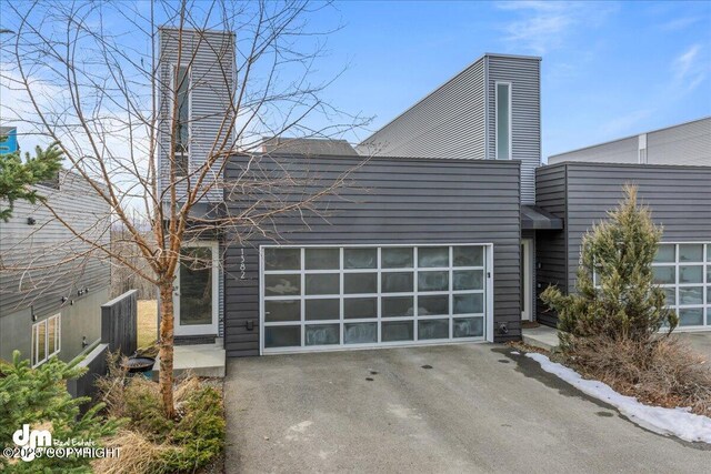 1382 Northbluff Dr # 4B, Anchorage, AK 99501 - view of front of property featuring an attached garage, a chimney, and aphalt driveway
