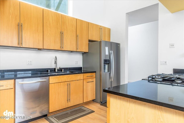 1382 Northbluff Dr # 4B, Anchorage, AK 99501 - kitchen featuring dark stone counters, light wood-style flooring, a sink, and appliances with stainless steel finishes