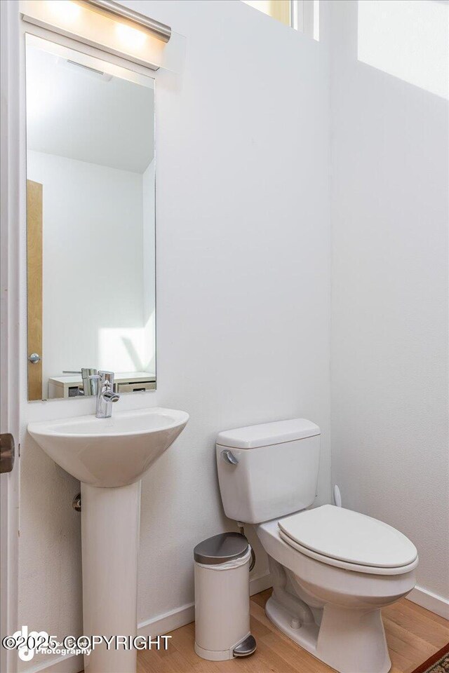 1382 Northbluff Dr # 4B, Anchorage, AK 99501 - half bathroom with baseboards, wood finished floors, a sink, and toilet