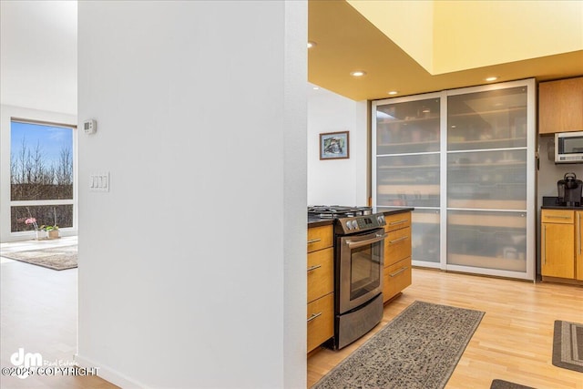 1382 Northbluff Dr # 4B, Anchorage, AK 99501 - kitchen with recessed lighting, light wood finished floors, stainless steel appliances, dark countertops, and brown cabinetry
