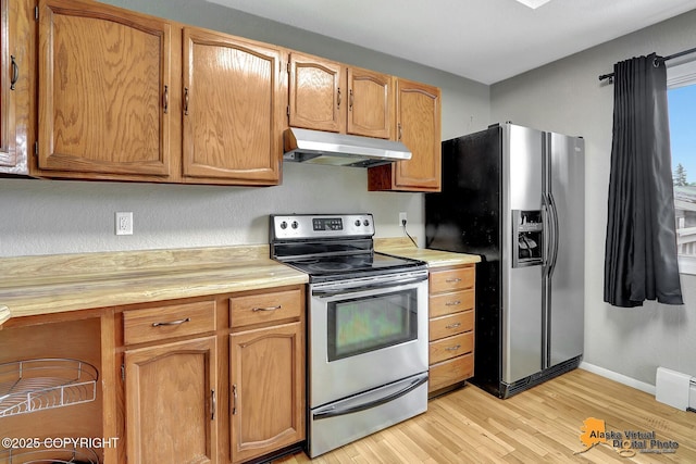 8400 E 11th Ct, Anchorage, AK 99504 - kitchen with appliances with stainless steel finishes, under cabinet range hood, light countertops, light wood finished floors, and baseboards