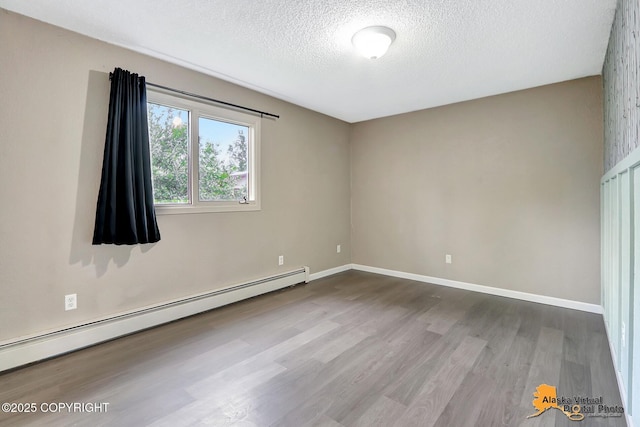 8400 E 11th Ct, Anchorage, AK 99504 - empty room with a baseboard heating unit, a textured ceiling, wood finished floors, and baseboards