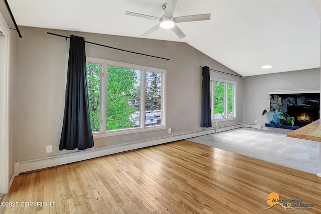 8400 E 11th Ct, Anchorage, AK 99504 - unfurnished living room featuring a baseboard heating unit, vaulted ceiling, hardwood / wood-style flooring, ceiling fan, and baseboards