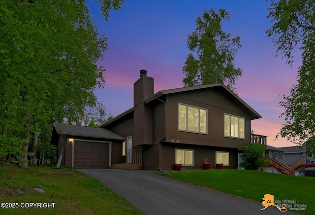 8400 E 11th Ct, Anchorage, AK 99504 - split level home featuring a chimney, a garage, a front lawn, and asphalt driveway