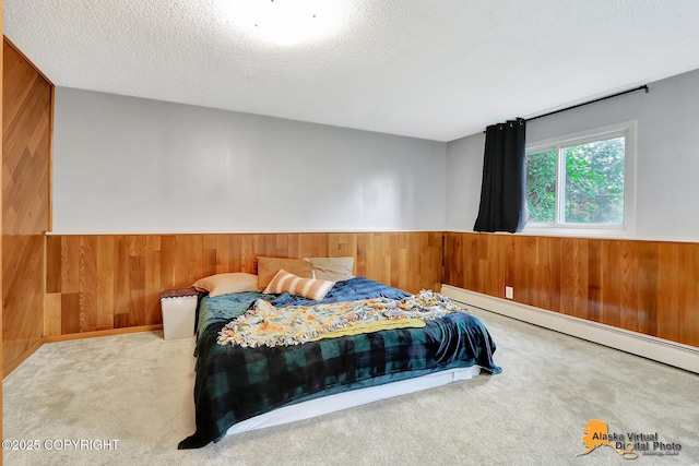 8400 E 11th Ct, Anchorage, AK 99504 - bedroom with wooden walls, carpet flooring, a textured ceiling, and a baseboard heating unit