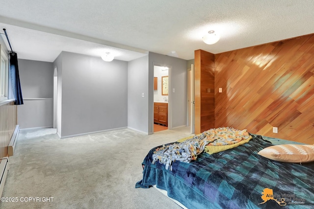 8400 E 11th Ct, Anchorage, AK 99504 - bedroom featuring light carpet, wooden walls, a baseboard radiator, baseboards, and a textured ceiling