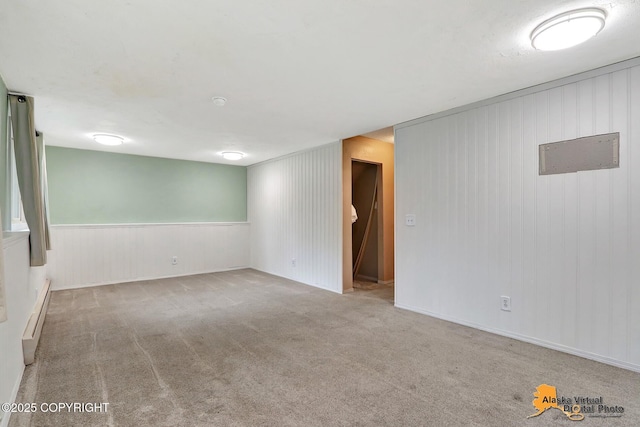 8400 E 11th Ct, Anchorage, AK 99504 - spare room featuring a baseboard heating unit, carpet floors, and wooden walls