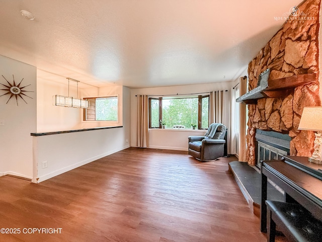 6934 Inlet Vista Dr, Wasilla, AK 99623 - living area featuring wood finished floors, a fireplace, and a textured ceiling