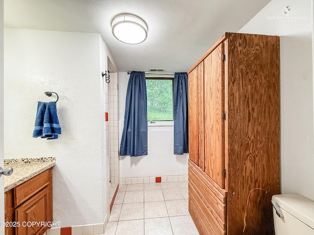 6934 Inlet Vista Dr, Wasilla, AK 99623 - full bathroom featuring vanity, a textured ceiling, tile patterned flooring, and a textured wall