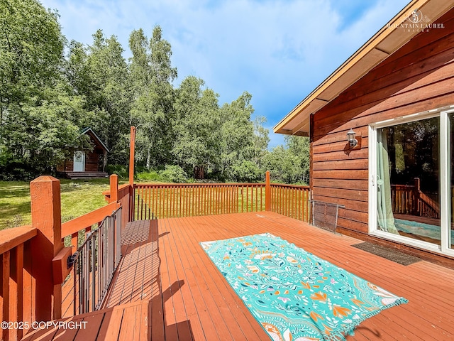 6934 Inlet Vista Dr, Wasilla, AK 99623 - wooden terrace featuring view of scattered trees and a lawn
