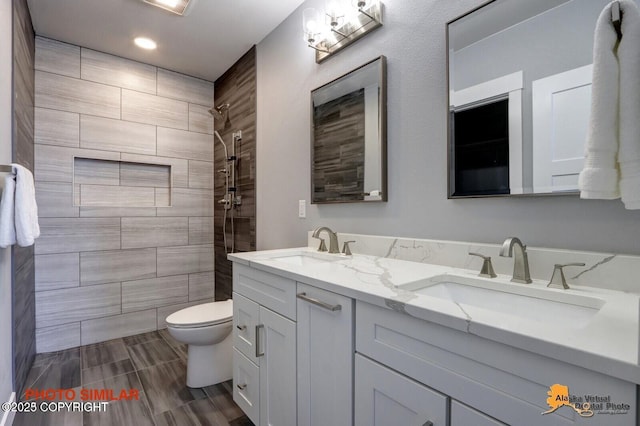 16074 Mountain Air Dr, Anchorage, AK 99516 - bathroom with double vanity, toilet, a tile shower, and recessed lighting