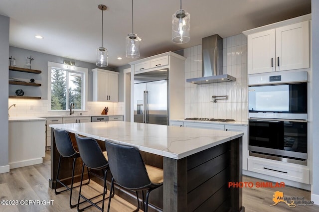 16074 Mountain Air Dr, Anchorage, AK 99516 - kitchen featuring wall chimney range hood, double oven, built in fridge, backsplash, and recessed lighting