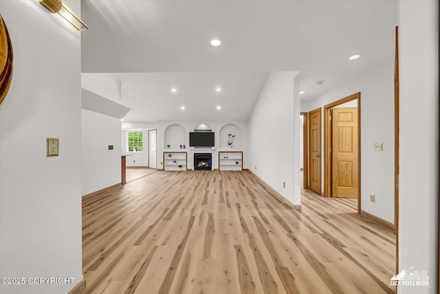 11510 Tulin Park Loop, Anchorage, AK 99516 - unfurnished living room with recessed lighting, light wood-style floors, a warm lit fireplace, and baseboards