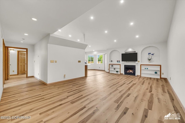 11510 Tulin Park Loop, Anchorage, AK 99516 - unfurnished living room with recessed lighting, light wood finished floors, baseboards, and a lit fireplace