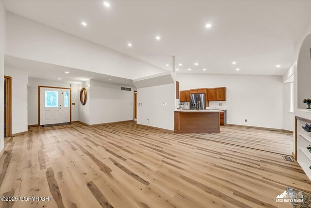 11510 Tulin Park Loop, Anchorage, AK 99516 - unfurnished living room with lofted ceiling, recessed lighting, and light wood-style floors