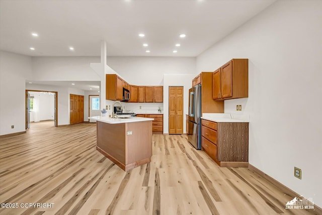 11510 Tulin Park Loop, Anchorage, AK 99516 - kitchen featuring appliances with stainless steel finishes, light countertops, a peninsula, recessed lighting, and brown cabinetry