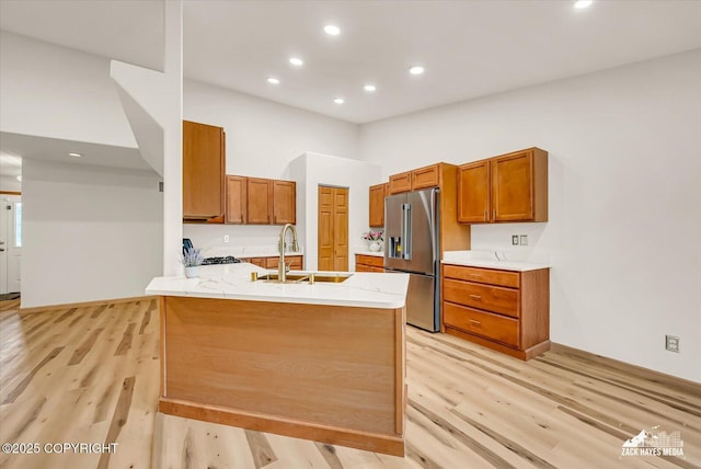 11510 Tulin Park Loop, Anchorage, AK 99516 - kitchen with high end fridge, a sink, light wood-style flooring, a peninsula, and brown cabinets