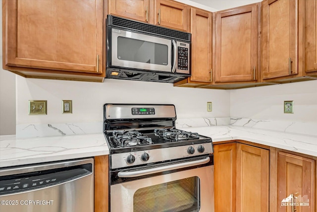 11510 Tulin Park Loop, Anchorage, AK 99516 - kitchen featuring appliances with stainless steel finishes, brown cabinetry, and light stone countertops