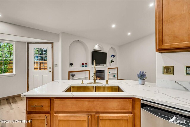 11510 Tulin Park Loop, Anchorage, AK 99516 - kitchen featuring stainless steel dishwasher, a sink, wood finished floors, open floor plan, and light stone countertops