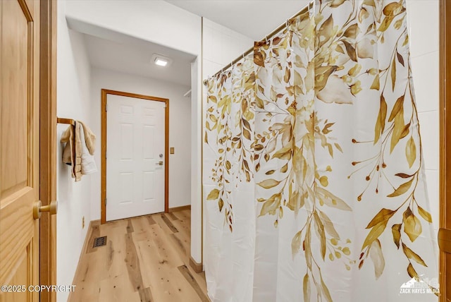 11510 Tulin Park Loop, Anchorage, AK 99516 - bathroom featuring wood finished floors, a shower with shower curtain, and baseboards