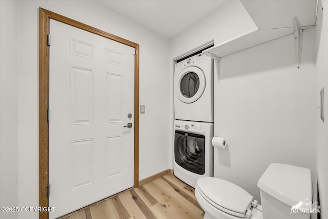 11510 Tulin Park Loop, Anchorage, AK 99516 - bathroom with estacked washer and dryer, wood finished floors, toilet, and baseboards