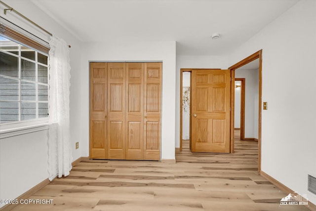 11510 Tulin Park Loop, Anchorage, AK 99516 - unfurnished bedroom featuring light wood finished floors, baseboards, and a closet