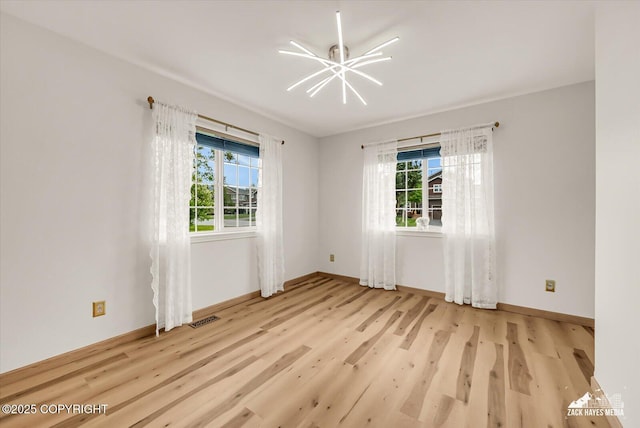11510 Tulin Park Loop, Anchorage, AK 99516 - empty room featuring healthy amount of natural light, light wood-style floors, and baseboards
